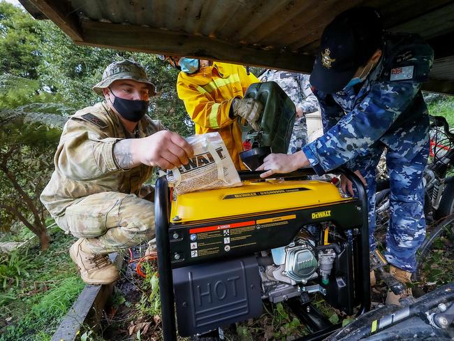 Crews deliver a generator to Ferny Creek resident Steve Hermans after many houses were left without power in last week’s storms. Picture: Ian Currie.