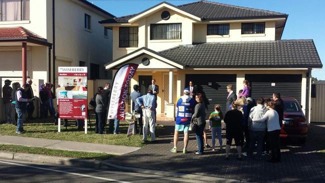 POPULAR AUCTIONS: Prospective buyers gather outside the auction for 183a Whitford Road, Hinchinbrook.