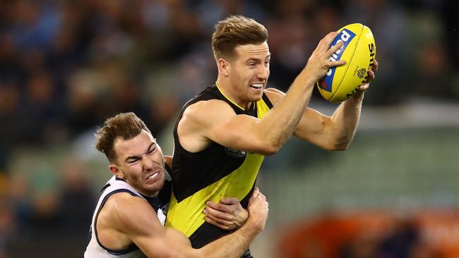 Richmond’s Kane Lambert tries to break the Geelong Cats tackle at MCG. Picture: Scott Barbour/Getty