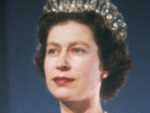 Queen Elizabeth II, dressed for a formal occasion. She wears her family's orders and orders of her kingdom on the sash over her shoulder, and several items of family jewelry.