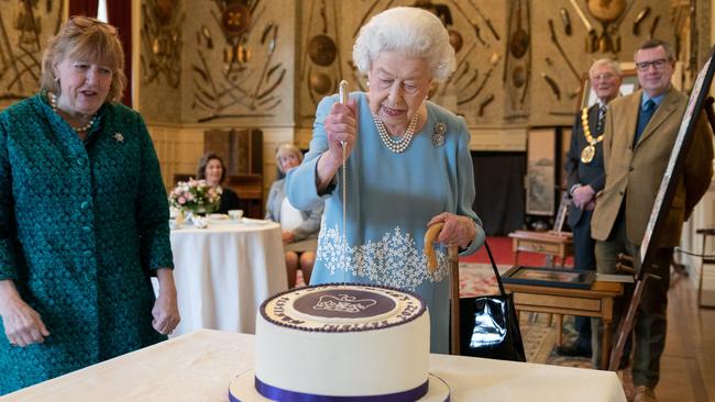 Queen Elizabeth cuts a cake to celebrate the start of the Platinum Jubilee during a reception in the Ballroom of Sandringham House. Picture: WPA Pool/Getty Images