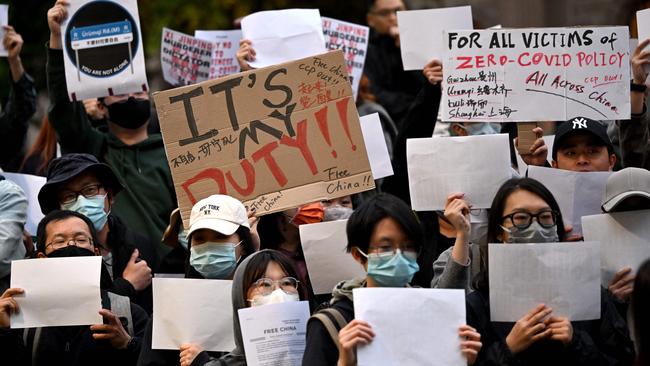 Members of the local Chinese community hold placards at a vigil in support of the protests against Beijing's zero-Covid policy taking place across China, in Melbourne.