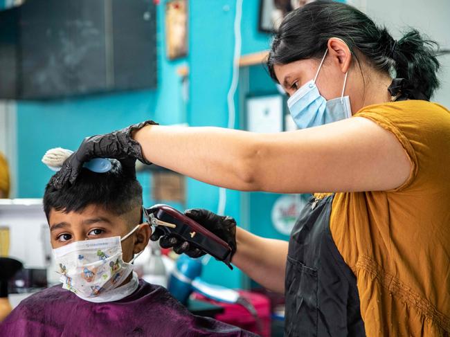 A young man gets his hair cut at a barber shop amid the coronavirus pandemic in Austin, Texas as the US looks to ease lockdowns. Picture: AFP