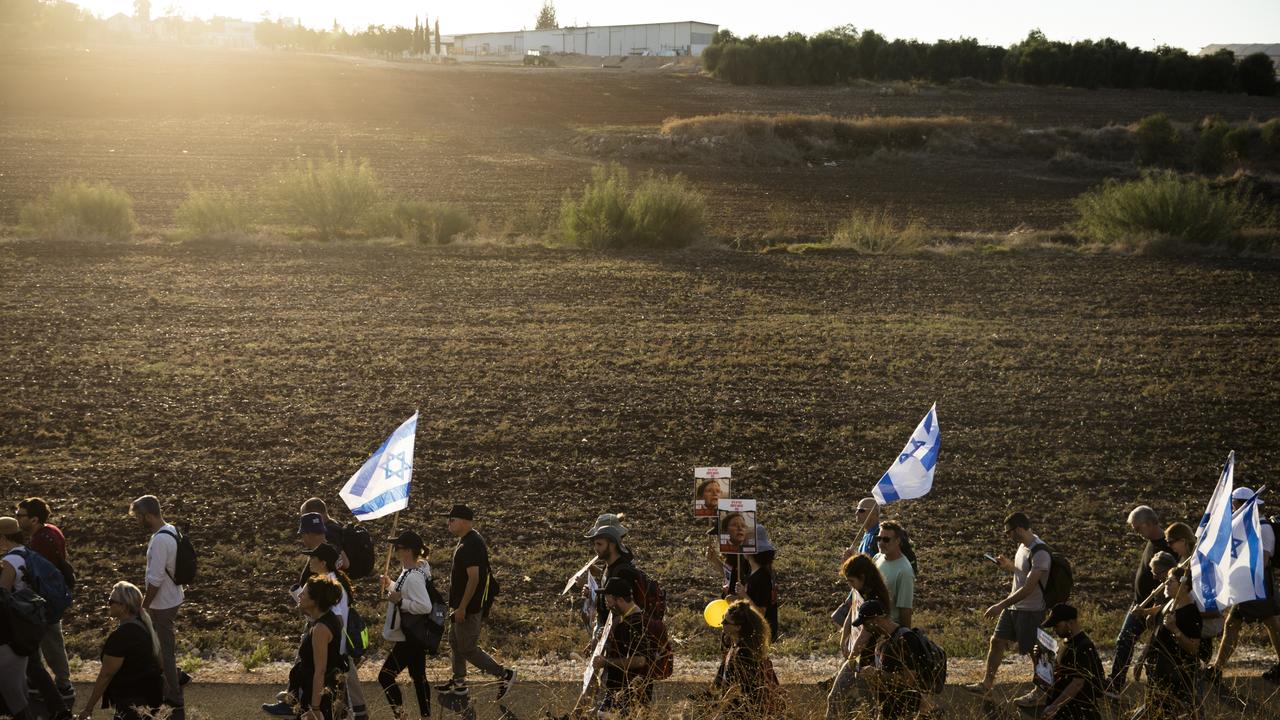 Family members, relatives and supporters hold posters showing hostages as they march to Jerusalem. Picture: Getty Images