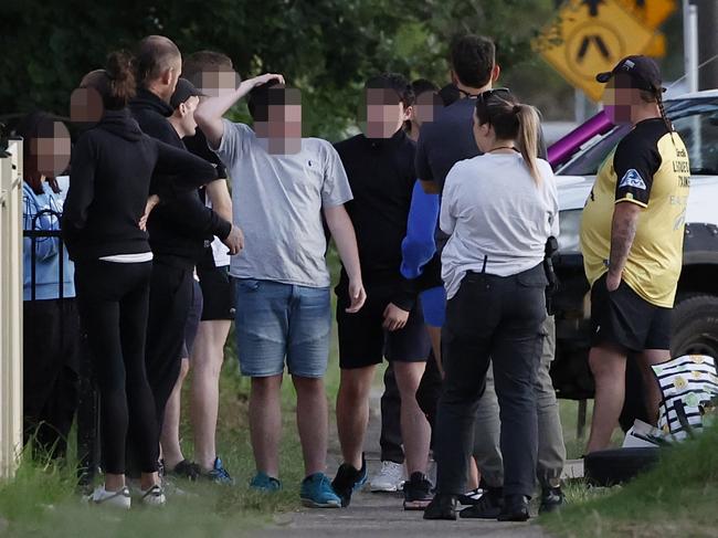 A detective talks to teens on Friday near the scene where two youths were stabbed. Picture: Richard Dobson