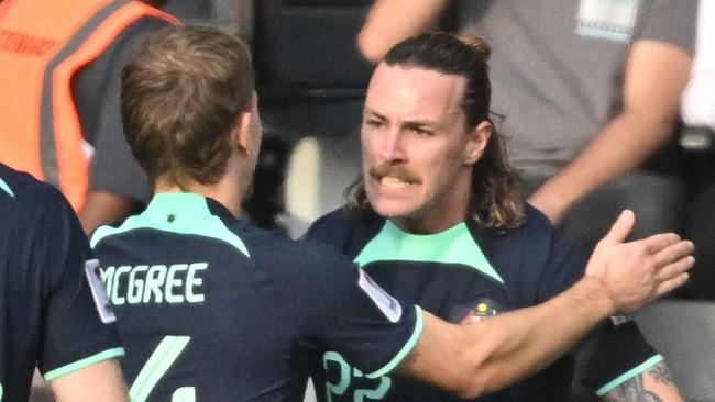 Australia's midfielder #22 Jackson Irvine celebrates with his teammates after scoring their first goal during the Qatar 2023 AFC Asian Cup Group B football match between Syria and Australia at the Jassim bin Hamad Stadium in Doha on January 18, 2024. (Photo by HECTOR RETAMAL / AFP)