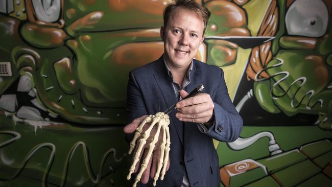 Dr Chris Jeffery holding a field orthopaedic micro screw in his office in Brisbane. 