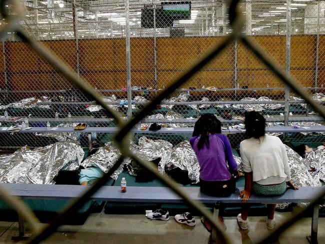 Two young girls sit in holding area where hundreds of mostly Central American immigrant children are being processed and held. Picture: AP Photo/Ross D. Franklin, Pool