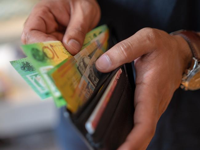 a male taking money out of a wallet, Australian cash generic spending