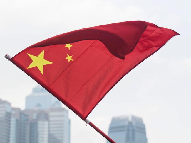 A youth waves the Chinese flag on November 13, 2016, during a rally in support of an interpretation of the city's constitution -- the Basic Law -- by China's National People's Congress Standing Committee (NPCSC), over the oath-taking attempts by newly elected lawmakers Baggio Leung and Yau Wai-ching at the Legislative Council last month. Thousands of people attended a pro-Beijing rally in Hong Kong on November 13 in support of China's decision to effectively bar two pro-independence legislators from taking office, as fears grow of the city's freedoms being under threat. / AFP PHOTO / ISAAC LAWRENCE