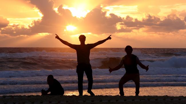 Morning sunrise for Aquinas College graduates Matt Simpson, Locki Marilia and Ben Feltell  on the Gold Coast. Picture AAP/David Clark