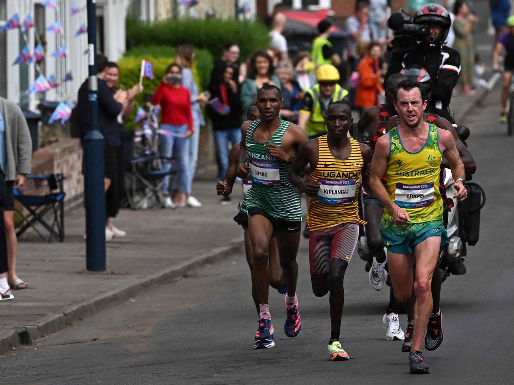 Tanzania's Alphonce Felix Simbu and eventual winner, Uganda's Victor Kiplangat, on Australia's Liam Adams, lead the field in the men's Marathon final on the shoulder of Liam Adams.