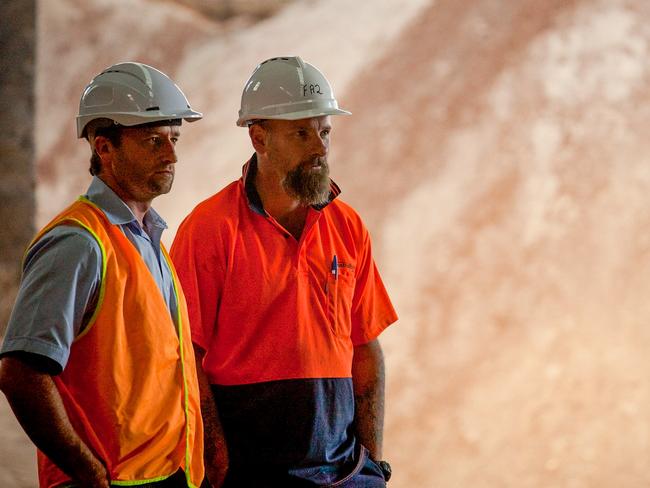 Austral Bricks Longford employees David Robertson and Jason Farrow in front of sawdust biomass used to heat the brick-making kilns. Picture: Supplied