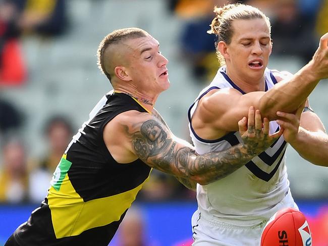 MELBOURNE, AUSTRALIA - MAY 06:  Nat Fyfe of the Dockers handballs whilst being tackled by Dustin Martin of the Tigers  during the round seven AFL match between the Richmond Tigers and the Fremantle Dockers at Melbourne Cricket Ground on May 6, 2018 in Melbourne, Australia.  (Photo by Quinn Rooney/Getty Images)