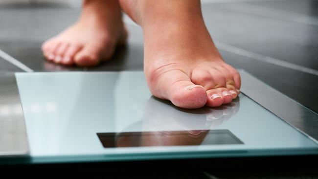 Female bare feet with weight scale in the bathroom, scales generic