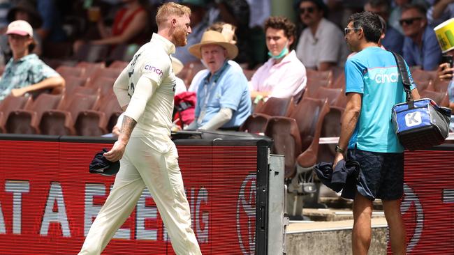 Ben Stokes leaves the field of play after hurting his side bowling.