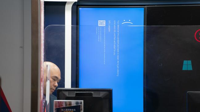 An error blue screen is displayed at a currency exchange store at the Hong Kong International Airport on Friday. Picture: Getty Images