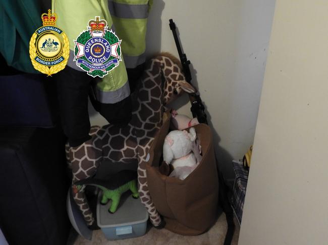 A firearm propped up against children’s toys inside the Caboolture property. Picture: Queensland Police Service/Australian Border Force