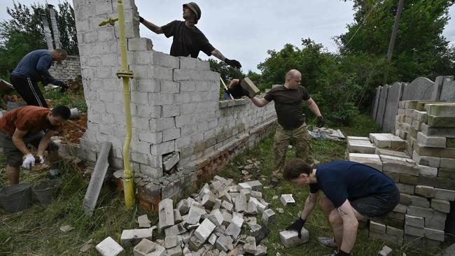 Volunteers of Repair Together charity organisation collect usable bricks of a destroyed residential house, in Shestovitsa village, Chernihiv region. Picture: AFP