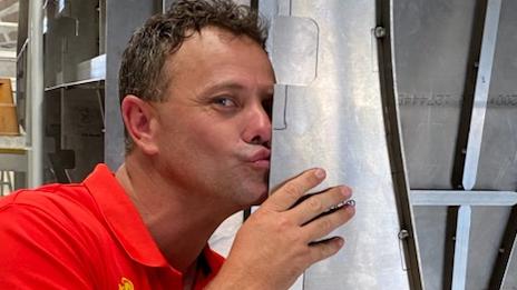 Red Cat Adventures owner Asher Telford kissing the hull of the new catamaran under construction on the Gold Coast. Picture: Contributed