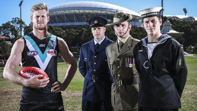 Port Adelaide captain Tom Jonas with Corporal Dominic Marshall (Air Force) Corporal Matthew Hood (Army) and Able Seaman Tom Borillo (Navy) before a previous Anzac Day clash. Picture: Sarah Reed