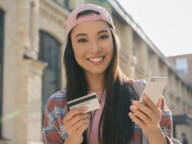 Beautiful Asian woman holding credit card shopping online