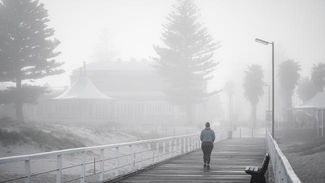 A walker in the fog at Grange Beach, Sunday, August 16. Picture: MIKE BURTON