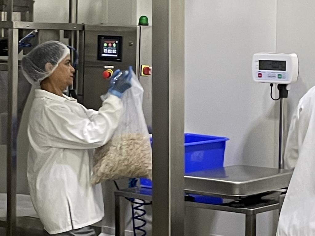 A worker at Proform Foods with a five kilogram bag of MEET.