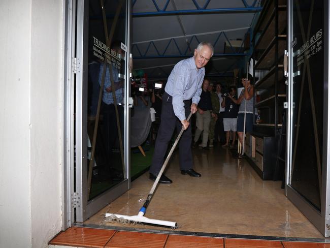 Malcolm Turnbull sweeps water during his tour of north Queensland. Picture: Gary Ramage