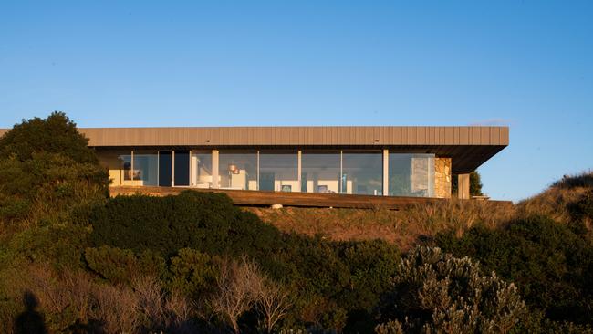 The three-bedroom house is nested above the dunes of Low Head beach.