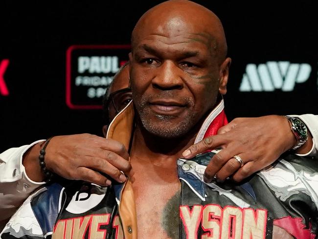 TOPSHOT - Former US heavyweight boxing champion Mike Tyson is assisted in removing his jacket during his weigh-in ahead of his heavyweight boxing match against US boxer and actor Jake Paul in Irving, Texas, on November 14, 2024. (Photo by TIMOTHY A. CLARY / AFP)