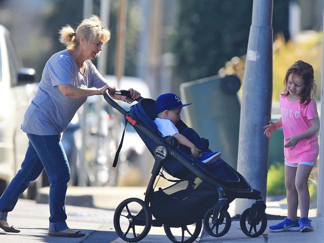 A carer with Roxy’s children Hunter and Pixie walking in Bondi yesterday.