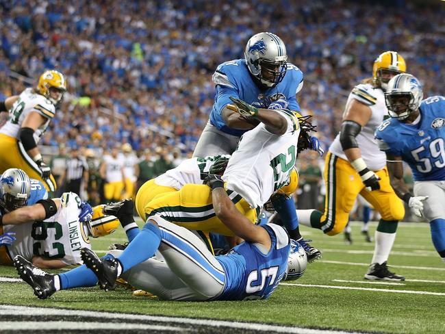Eddie Lacy #27 of the Green Bay Packers is tackled in the end zone for a safety by DeAndre Levy #54 and Isa Abdul-Quddus #42 of the Detroit Lions.
