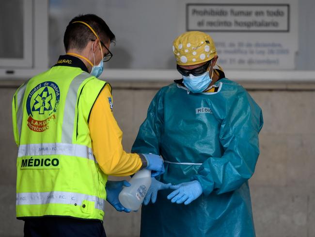 Healthcare workers disinfect their protective gear in Madrid. New COVID cases in Europe are surging. Picture: AFP