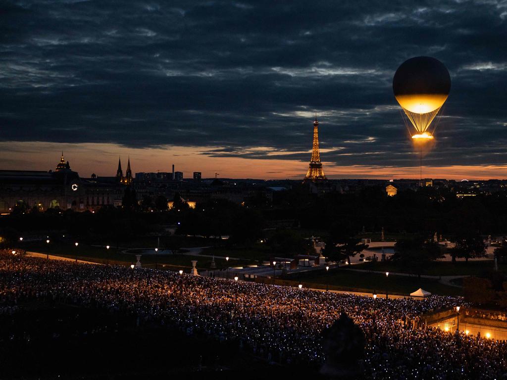 Take off: This photograph taken from the Musee des Arts Decoratifs shows the crowd pointing their phones towards the cauldron of the Paris 2024 Olympic and Paralympic Games during its takeoff as it is attached to a balloon, in the Tuileries garden in Paris, with the Eiffel tower in the background, on August 8, 2024. Picture: AFP