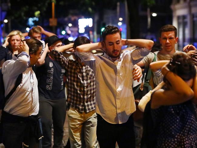 People leave the area with their hands up after an incident near London Bridge. Picture: Reuters/Neil Hall