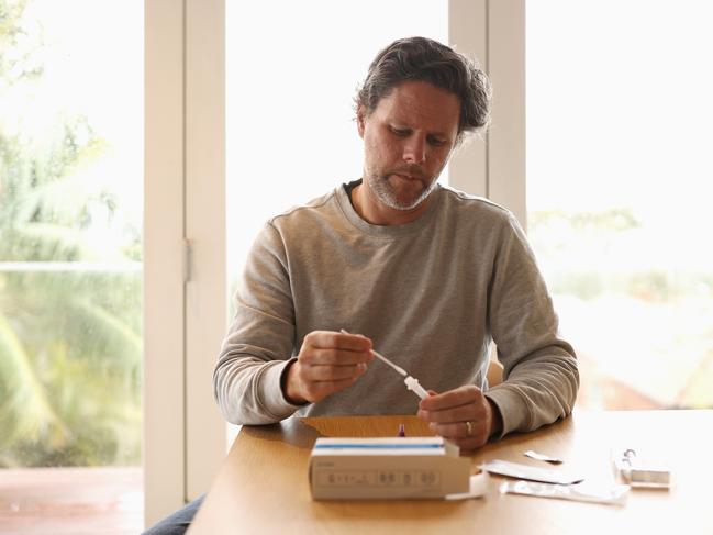 A man uses a COVID-19 rapid antigen test kit at home. Picture: Getty Images