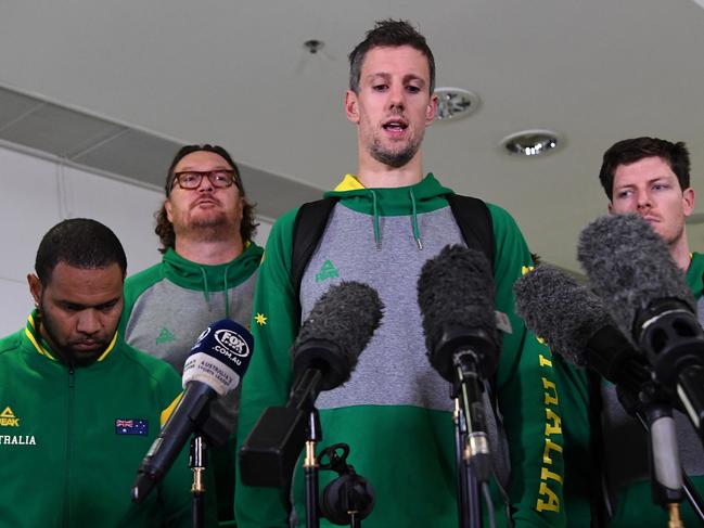 Daniel Kickert of the Boomers, the Australian national basketball team (centre), speaks to the media as he arrives at Brisbane airport, Wednesday, July 4, 2018. Some Boomers players were involved in an on-court brawl during a world cup qualification game against the Philippines national team in Bulacan yesterday. (AAP Image/Dan Peled) NO ARCHIVING