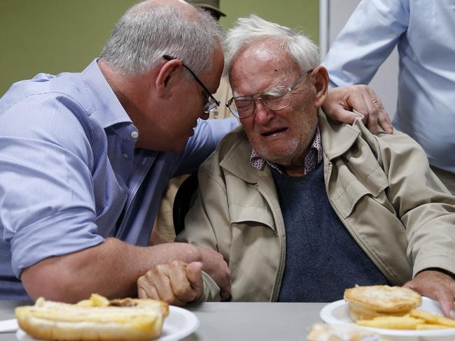 Prime Minister Scott Morrison is seen comforting 85 year old Owen Whalan of Half Chain road in Koorainghat who has been evacuated from his home during a visit to Club Taree Evacuation Centre in Taree, New South Wales, Sunday, November 10, 2019. (AAP Image/Darren Pateman) NO ARCHIVING