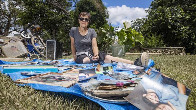 Sandy Hobbs attempts to dry out photos from family albums damaged as floodwaters inundated her home. Picture: Lachie Millard