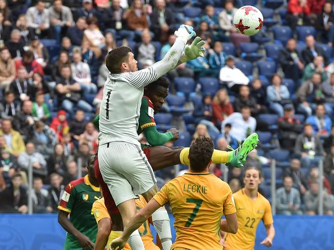 Australia's goalkeeper Mat Ryan jumps to block the ball.