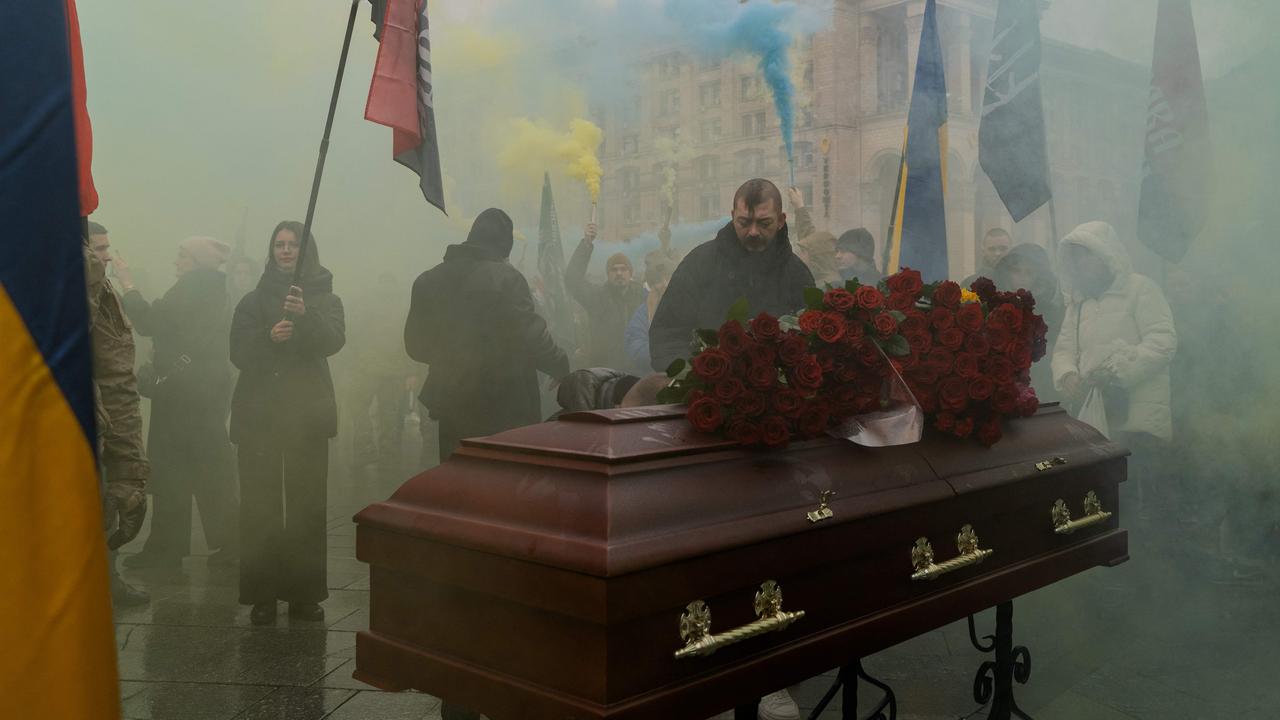 Mourners hold smoke flares next to the coffin of Pavlo Vedybida, callsign "Obolonchyk", a Ukrainian serviceman and ultras member of Football Club Obolon Kyiv, who was killed in the battle near the town of Chasiv Yar, Donetsk region. Picture: Tetiana Dzhafarova / AFP