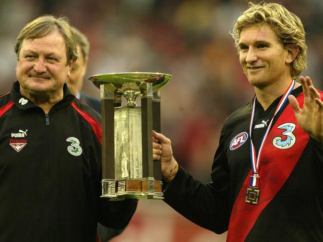 MELBOURNE, AUSTRALIA - APRIL  25: Kevin Sheedy coach of the Bombers and James Hird captain and Anzac Day Medallist hold the Anzac Day Cup after winning the round five AFL Anzac Day match between the Collingwood Magpies and the Essendon Bombers at the Melbourne Cricket Ground April 25 2004 in Melbourne, Australia. (Photo by Mark Dadswell/Getty Images)