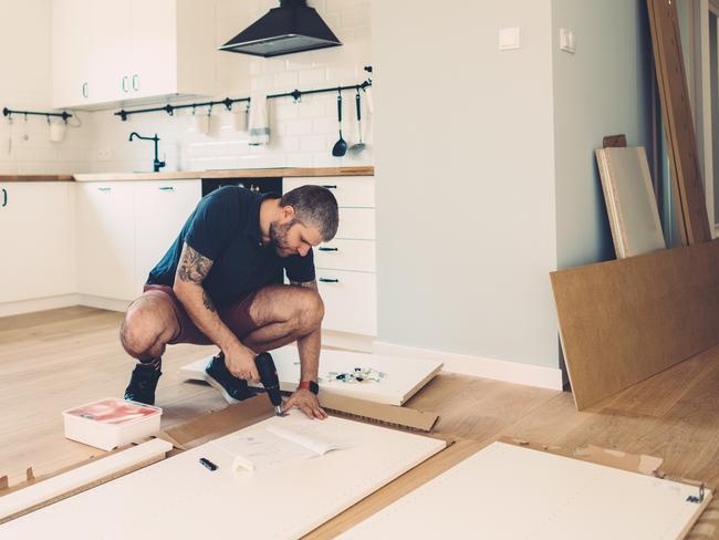 Mid adult man assembling wardrobe for his new home