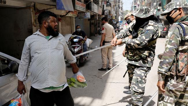 Police officers in New Delhi wield their batons against a man as punishment for breaking the lockdown rules. Picture: Reuters