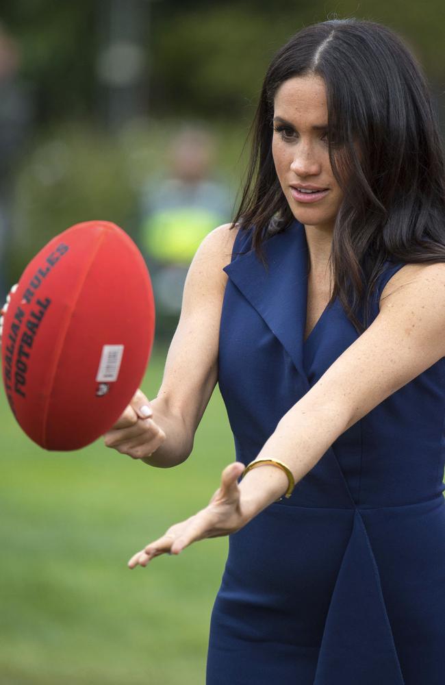 Meghan, Duchess of Sussex passes an Australian Rules football during an event at Government House in Melbourne. Picture: AP