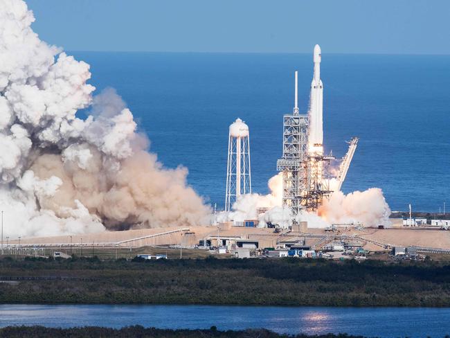 The SpaceX Falcon Heavy takes off from Pad 39A at the Kennedy Space Center in Florida, on February 6, 2018, on its demonstration mission. The world's most powerful rocket, SpaceX's Falcon Heavy, blasted off Tuesday on its highly anticipated maiden test flight, carrying CEO Elon Musk's cherry red Tesla roadster to an orbit near Mars. Screams and cheers erupted at Cape Canaveral, Florida as the massive rocket fired its 27 engines and rumbled into the blue sky over the same NASA launchpad that served as a base for the US missions to Moon four decades ago.  / AFP PHOTO / JIM WATSON