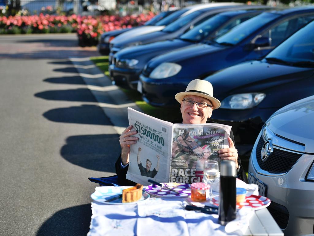 Catching up on the morning’s racing news in the Herald Sun. Picture: Jason Edwards