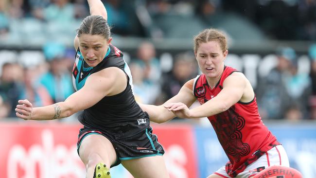 Abbey Dowrick gets her kick away despite pressure from Amber Clarke. Picture: Sarah Reed/AFL Photos via Getty Images