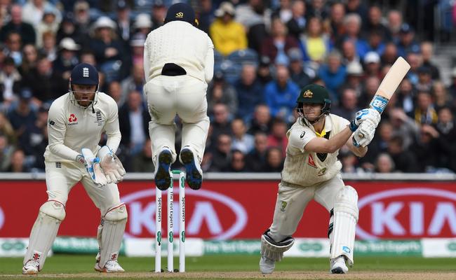 Jos Buttler jumps over the ball as Steve Smith hits out. Picture: AFP